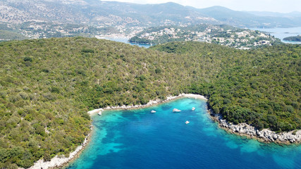 Aerial drone bird's eye view photo of popular and iconic turquoise beach of Bella Vraka in island of Mourtemeno with sunbeds and canoes forming a blue lagoon, Sivota bay, Epirus, Greece