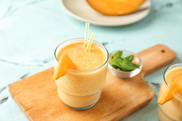 Glass of tasty melon smoothie on table