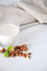 Glass of Almond Milk with Almonds on Background