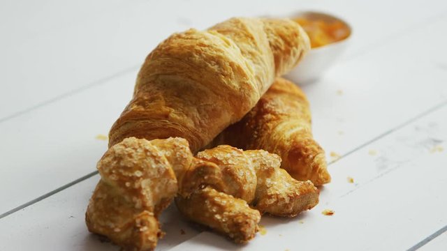 Heap of fresh crunchy croissants laid on white wooden background