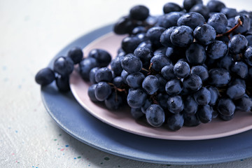 Plates with ripe sweet grapes on light table