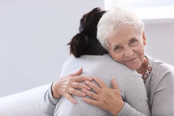 Foto op Plexiglas Zorgcentrum Gelukkige bejaarde vrouw met haar dochter thuis
