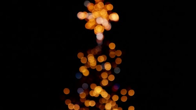 White lights flashing over orange ones. Fuzzy christmas tree.