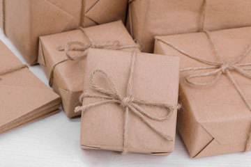 Postal parcels. boxes wrapped in craft paper on a white wooden table. mail or delivery concept