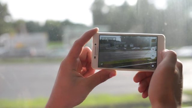 Tourist with Mobile Sell Phone in Hands recording video view of the streets city