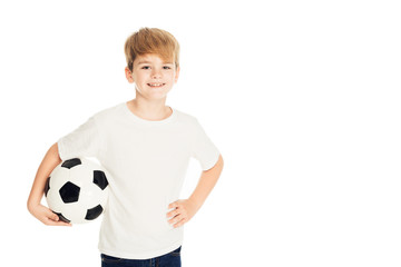 smiling adorable boy holding football ball and looking at camera isolated on white