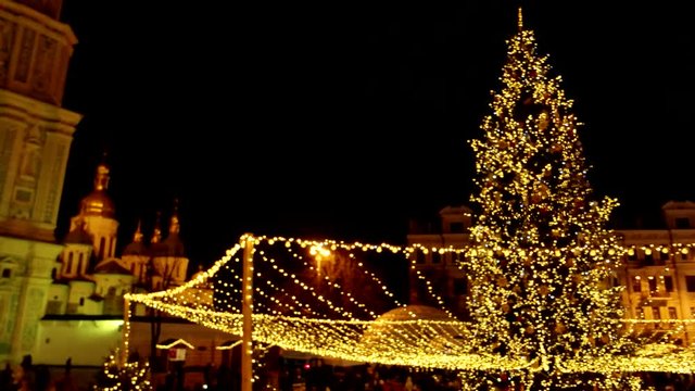 Amusement park beside the Christmas tree. Celebrating people are everywhere.