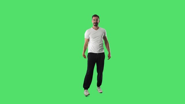 Funny young man scolding finger energetically looking at camera. Full body isolated on green screen background. 