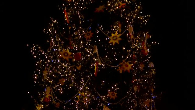 Giant Christmas tree decorated with lights, stars and toys. Christmas tree at night.