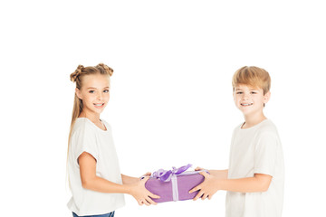 smiling boy presenting gift box to friend isolated on white and they looking at camera