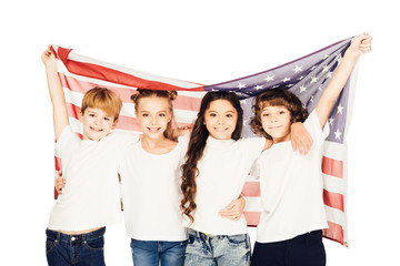 Obraz premium smiling adorable children standing under american flag and looking at camera isolated on white