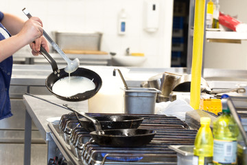 Chef in hotel or restaurant kitchen cooking 
