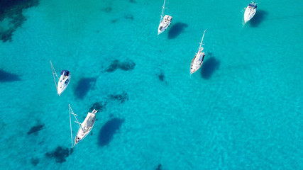 Fototapeta na wymiar Aerial drone top view photo of luxury sail boats docked in tropical bay with turquoise and emerald clear sea