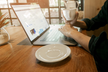 Close up young man working with his computer in coffee shop