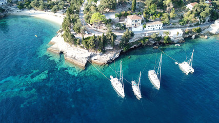 Aerial drone bird's eye view photo of iconic small port and fishing village of Logos with traditional Ionian architecture and sail boats docked, Paxos island, Ionian, Greece