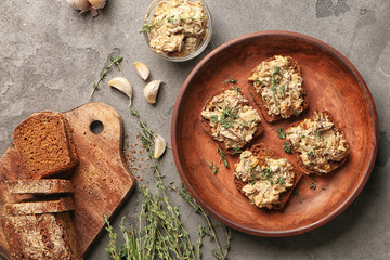 Tasty sandwiches with spread and fresh herbs on plate