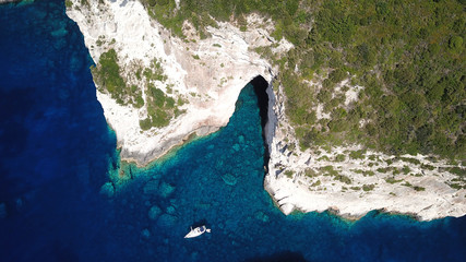 Aerial drone bird's eye view photo of tropical rocky bay of Ortholithos with famous cave of Papanikolis and turquoise calm waters forming a blue lagoon
