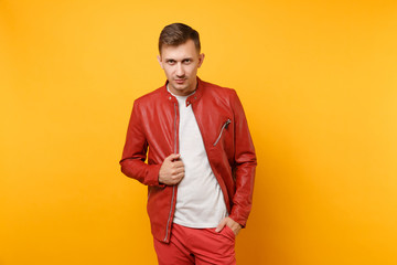 Portrait vogue confident handsome young man 25-30 years in red leather jacket, t-shirt stand isolated on bright trending yellow background. People sincere emotions lifestyle concept. Advertising area.