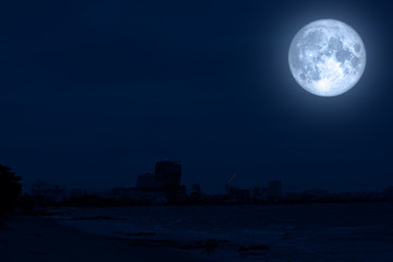 Fototapeta na wymiar full blue moon back silhouette city beach coast