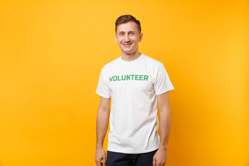 Portrait of happy smiling satisfied young man in white t-shirt with written inscription green title...