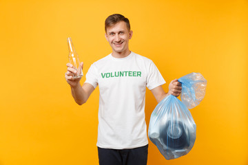 Man in t-shirt volunteer, trash bag isolated on yellow background. Voluntary free assistance help, charity grace. Environmental pollution problem. Stop nature garbage environment protection concept.