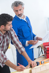 Obraz premium carpentry apprentice getting instructions from the teacher