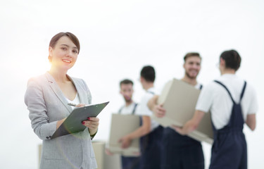 Woman manager holding clipboard on blurred background with mover