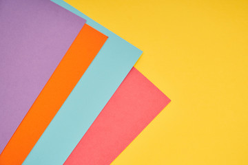 pink, blue, orange and purple paper on yellow background