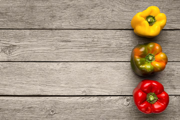 Variation of different color bell peppers on wooden background