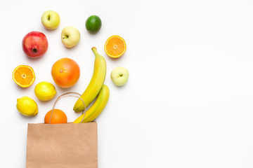 Paper bag with fruit assortment on white background