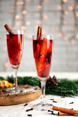 Glasses of delicious mulled wine on white wooden table