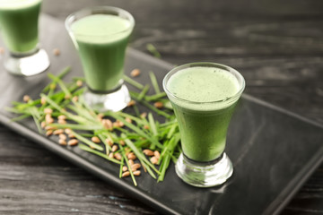 Shots of healthy wheat grass juice on plate