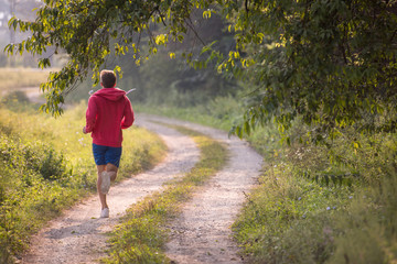Fototapeta premium man jogging along a country road