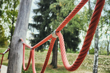 Fototapeta na wymiar red rope loop wooden playground mannheim kids play fun happy nature eco sand climbing metal