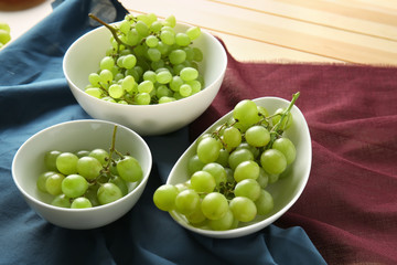 Plates with ripe sweet grapes on table