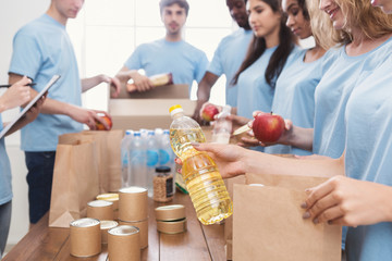 Volunteers packing food and drinks into paper bags