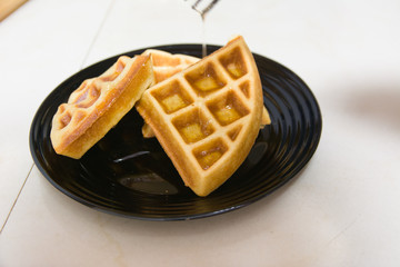 Traditional belgian waffles on a black plate