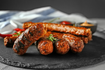 Tasty grilled sausages on slate plate