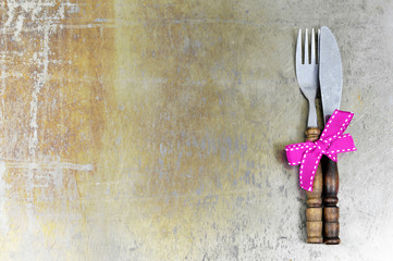 Fork and knife tied with pink ribbon