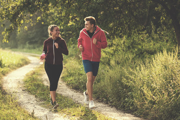 Jeune couple jogging le long d& 39 une route de campagne