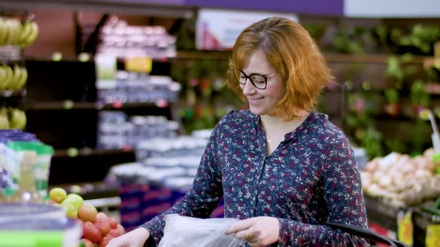 Beautiful and young redhead woman holding a fresh chayote or chuchu (Sechium edule)