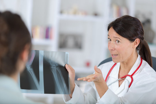 female dentist showing x-rays to patient