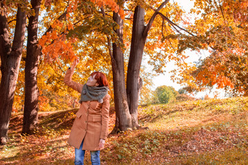 Cheerful redhead woman enjoying in park.