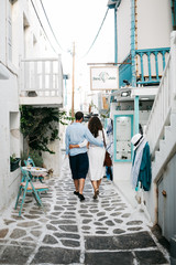 A young couple walking on the street of Greek town