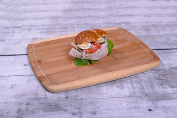 Fresh sendwich with ham, lettuce, quail eggs, cheese and tomatoes