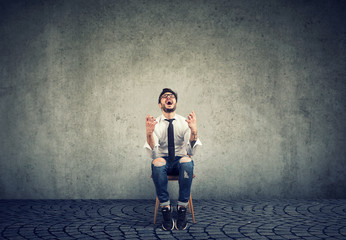 Stressed business man sitting on a chair feeling overworked screaming