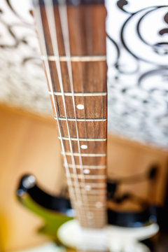 electro guitar neck standing on the blurred floor