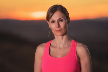 Fototapeta premium Young beautiful woman portrait in sport clothes at sunset