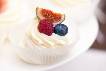 Fresh cupcake muffins with raw berries. Sweets decorated