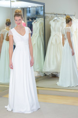 Naklejka premium girl standing in the bright studio in a wedding dress